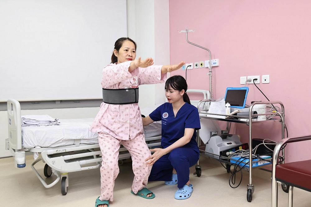 Kỹ thuật viên Lê Thị Tuyến tập tăng cường sức mạnh cơ và thăng bằng cho người bệnh. Ảnh: NVCC